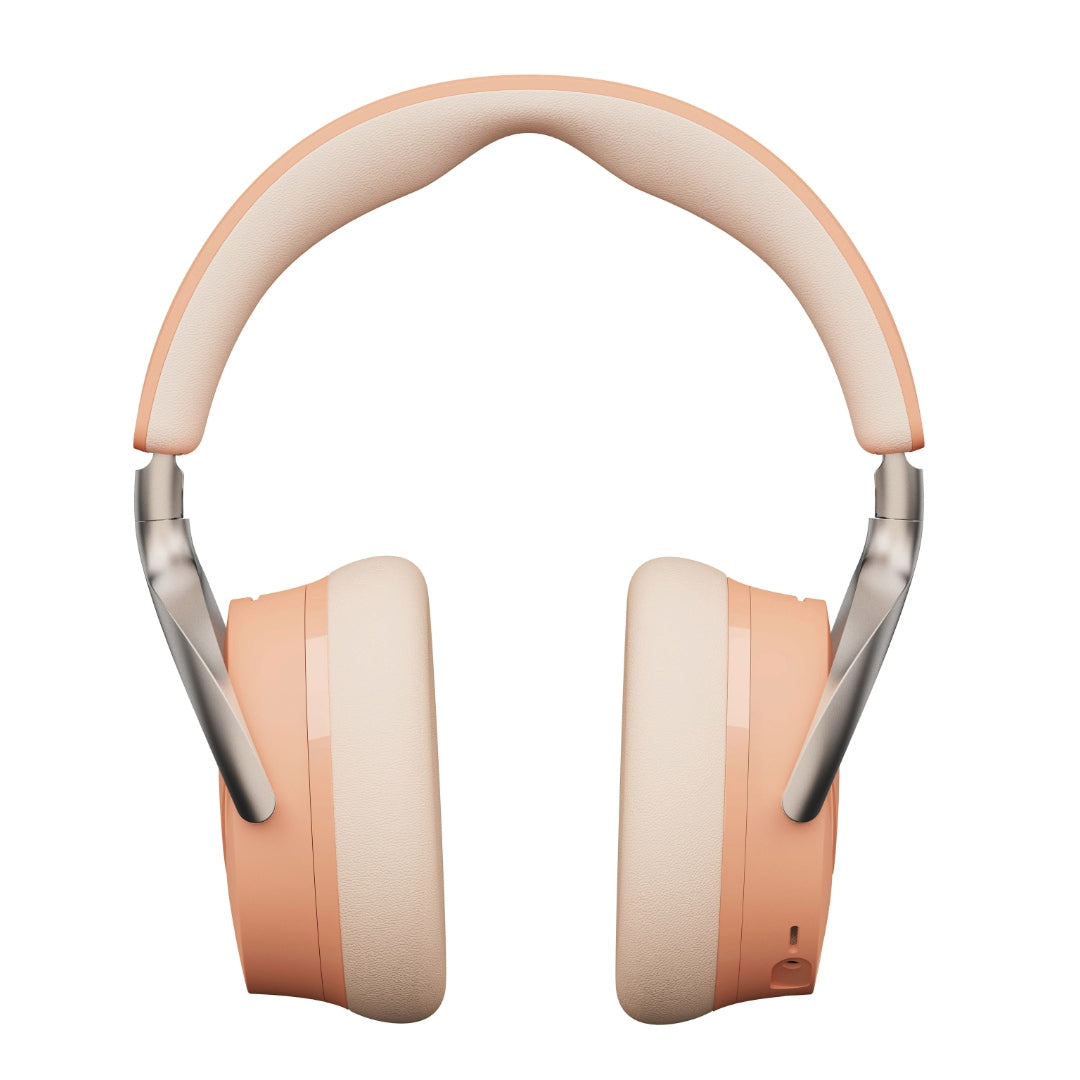 Over-ear wireless headphones with peach-colored earcups and a cream padded headband,
